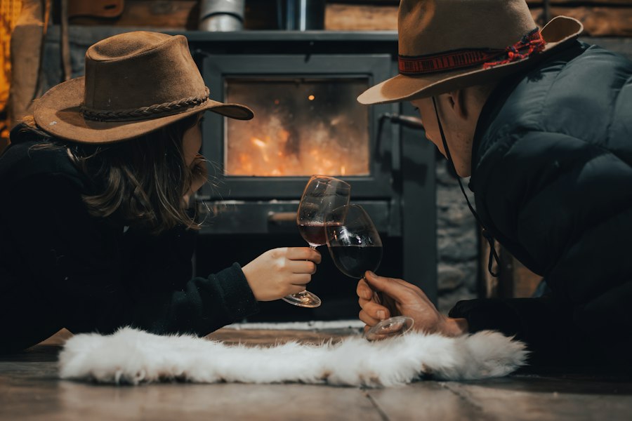 Casal brindando com vinho ao lado da lareira