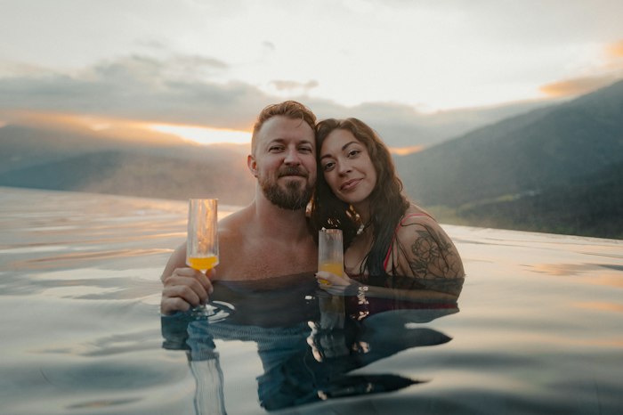 Reel de um casal brindando na piscina com vista para a serra